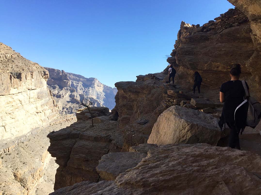 A walker on the rocky rim of the canyon on Jabal Shams