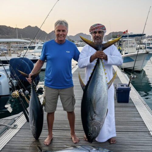Two anglers on a jetty holding large tuna