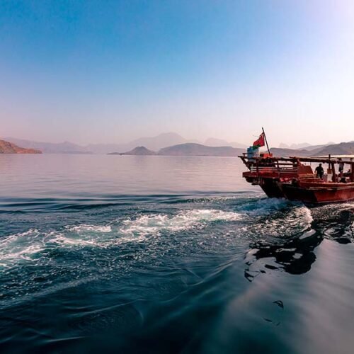 A dhow speeding through a fjord in Musandam