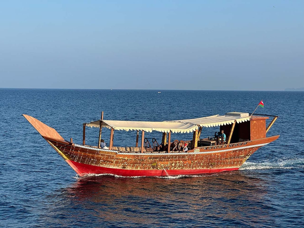 A traditional wooden dhow on calm blue water