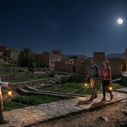 Walkers with lanterns in Misfat under a full moon