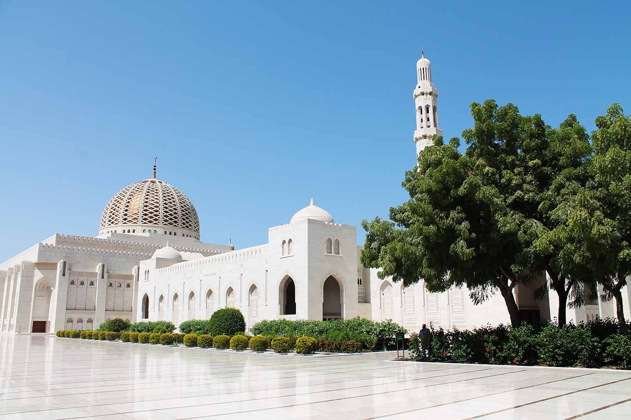 The Sultan Qaboos Grand Mosque with its dome and minaret behind gardens
