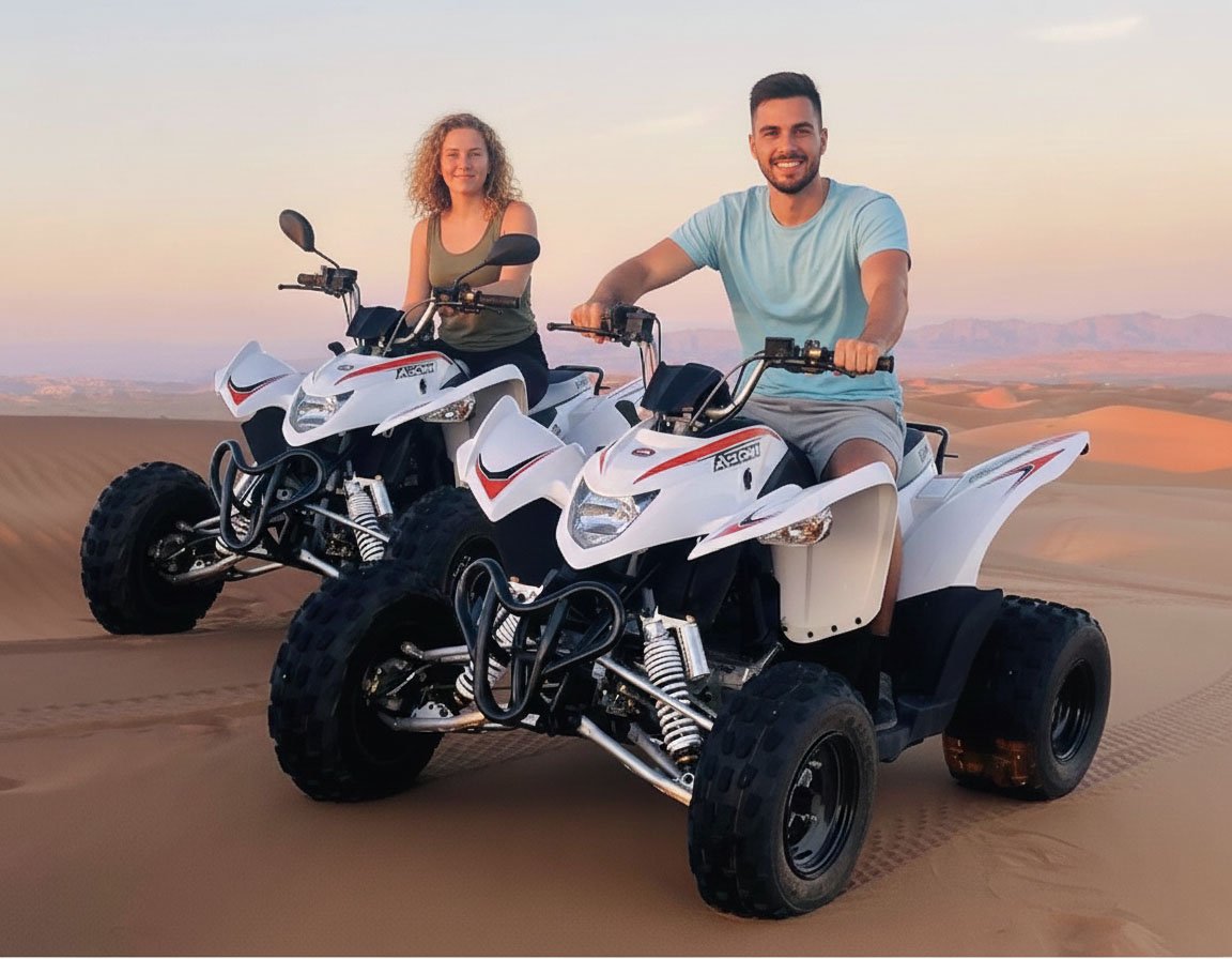 Two riders on quad bikes in the dunes