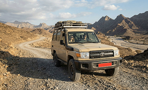 A 4x4 with a roof rack on a mountain track
