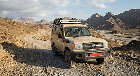 A 4x4 with a roof rack on a mountain track