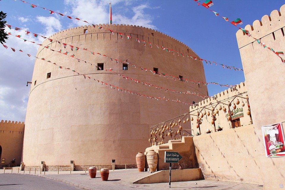 The round tower of Nizwa Fort, with flags strung along the walls