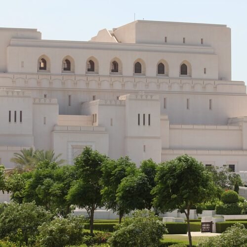 The Royal Opera House Muscat behind trees and lawns