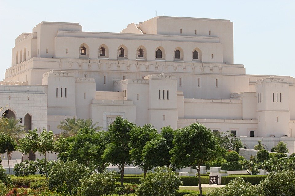 The Royal Opera House Muscat behind trees and lawns