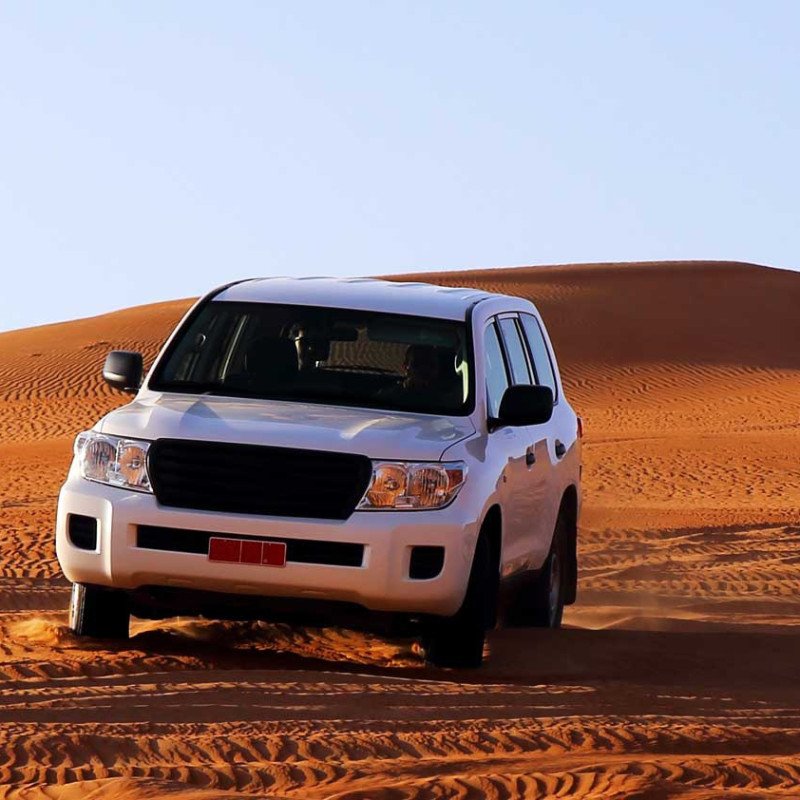 A white 4x4 on a sand dune