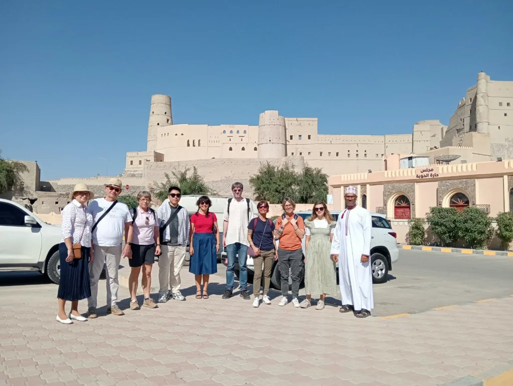 A group of guests with their guide in front of a large historic fort