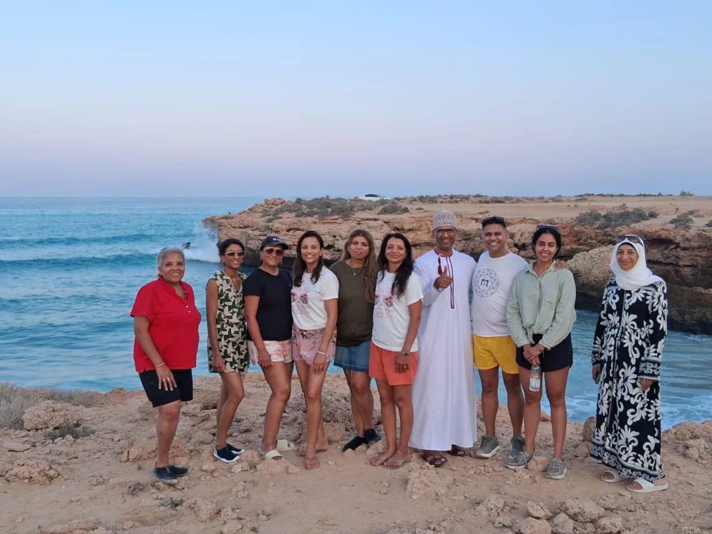 A group of guests and their guide on coastal cliffs at sunset