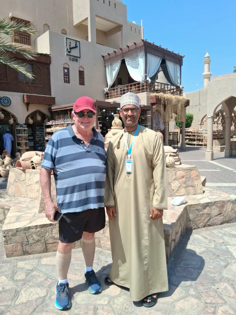 A guest with an Omani guide in a traditional souq square